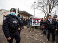 Police officers stand outside Adamson Barbecue restaurant, which had opened despite being ordered closed the day before, in the Toronto suburb of Etobicoke on Nov. 25, 2020.