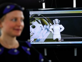 A monitor shows an computer-generated image of AFP journalist Helen Perceval (L) as she is filmed wearing a motion capture suit in a special effects studio at Framestore in London 31 January, 2014. PHOTO BY ADRIAN DENNIS/AFP via Getty Images.