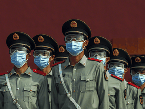 Chinese paramilitary police wear protective masks as they guard the entrance to the Forbidden City as it reopened to limited visitors this year.