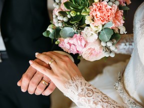 Closeup groom and bride are holding hands at wedding day ang show rings. Concept of love family