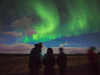 Tourists take photos of the Northern Lights near Reykjavik, Iceland.