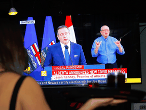 A television at a Calgary bar shows Alberta Premier Jason Kenney speaking as he places new restrictions to help fight the rise in COVID-19.