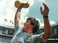 Argentine soccer star Diego Maradona holds up the World Cup trophy as he is carried off the field after Argentina defeated West Germany 3-2 to win the World Cup soccer championship in Mexico City on June 29, 1986.
