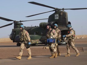 Canadian medical personnel move a patient from a Chinook helicopter to a waiting ambulance during a demonstration on the United Nations base in Gao, Mali, on December 22, 2018.