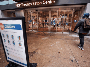 A man arrives at the entrance to the Eaton Centre in downtown Toronto, on November 23, 2020, the first day of a new lockdown in the city.