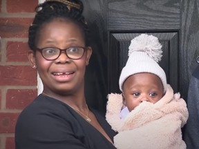 Dr. Perpetual Uke holds one of her twins outside her home. PHOTO BY SKY NEWS VIA YOUTUBE.