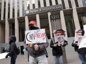 Qanon activists rally as they shout "We are Q" to show their support for Fox News outside their headquarters in the Manhattan borough of New York City, New York, U.S., November 2, 2020. PHOTO BY CARLO ALLEGRI/REUTERS.