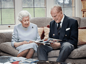Queen Elizabeth II and Prince Philip, look at a homemade wedding anniversary card given to them by their great grandchildren Prince George, Princess Charlotte and Prince Louis, at Windsor Castle ahead of their 73rd wedding anniversary, on November 17, 2020.