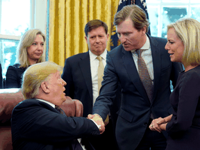 U.S. President Donald Trump shakes hands with Chris Krebs, the director of the Cybersecurity and Infrastructure Security Agency, in November 2018.