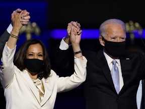 Vice President-elect Kamala Harris holds hands with President-elect Joe Biden and her husband Doug Emhoff as they celebrate, in Wilmington, Del.,Saturday, Nov. 7, 2020.