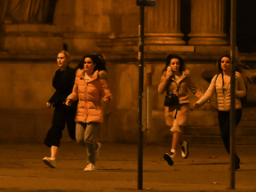 Women run away from the first district near the state opera, central Vienna on November 2, 2020, following a shooting near a synagogue.
