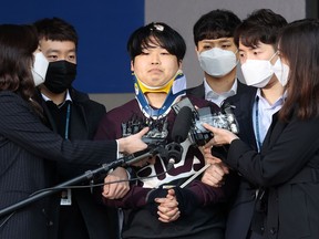 This picture taken on March 25, 2020 shows Cho Ju-bin (C), who ran an online sex abuse ring, walking out of a police station as he is transferred to the prosecutors' office in Seoul.