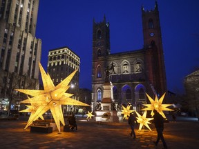 Christmas decorations are seen in front of the Notre-Dame Basilica in Montreal, Thursday, Nov. 19, 2020.&ampnbsp;Members of religious minority groups in Quebec are decrying the provincial government's plan to allow Christmas-time gatherings in the midst of the COVID-19 pandemic, calling the move a sign of a double standard.