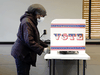 A woman casts her absentee in-person ballot at a polling site  in Milwaukee, October 20, 2020. Security experts have dismissed U.S. President Donald Trump's accusations of massive voter fraud in the general election.