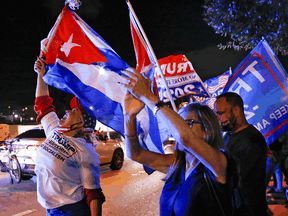 A supporter of U.S. President Donald Trump holds a Cuban flag during the 2020 U.S. presidential election, in Miami, Florida, November 3, 2020.