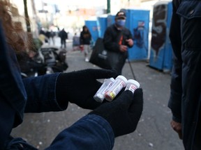 A fentanyl user displays a "safe supply" of opioid alternatives, provided by the local health unit to combat overdoses due to poisonous additives and to support addicts and the homeless in practicing social distancing to help slow the spread of coronavirus disease (COVID-19) in the Downtown Eastside of Vancouver, British Columbia, Canada April 6, 2020.