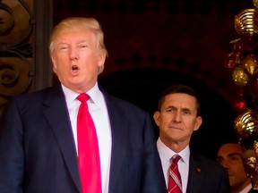 In this file photo taken on December 21, 2016 US President-elect Donald Trump (L) stands with Trump National Security Adviser designate Lt. General Michael Flynn (R) at Mar-a-Lago in Palm Beach, Florida.