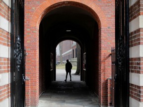 A man walks through a gate to the Yard at Harvard University in Cambridge, Massachusetts, U.S., March 10, 2020.