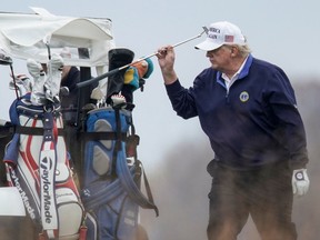 U.S. President Donald Trump replaces his putter as he plays golf at the Trump National Golf Club in Sterling, Virginia, U.S., November 15, 2020.