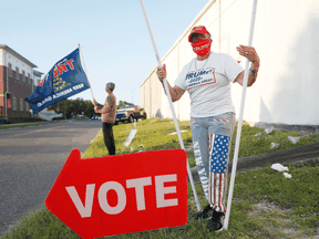 A woman waves Trump 2020 flags at voters on November 3, 2020 in Tampa, Florida.