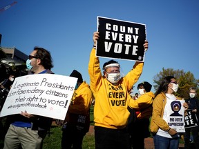 People hold sign as they take part in a rally demanding a fair count of the votes of the 2020 U.S. presidential election, in Philadelphia, Pennsylvania, U.S., November 4, 2020.