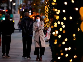 A pedestrian walks past a Christmas-themed window display at a department store in London.