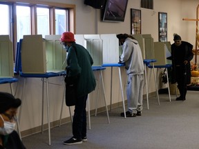 Voters wearing protective masks cast ballots at a polling location for the 2020 Presidential election in Milwaukee, Wisconsin, U.S., on Tuesday, Nov. 3, 2020.