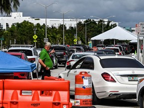 People wait inside vehicles at a drive-through COVID-19 testing site in Miami Beach, Florida on November 17, 2020.