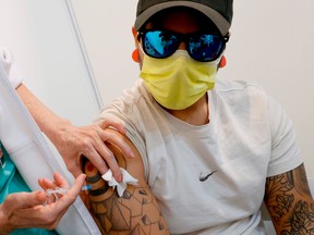 A healthcare worker vaccinates a man with the Pfizer-BioNtech Covid-19 vaccine at a large vaccination centre open by the Tel Aviv-Yafo Municipality and Tel Aviv Sourasky Medical Center on December 31, 2020 in the Israeli coastal city.