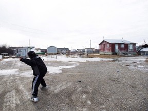 A boy plays on the northern Ontario First Nation reserve in Attawapiskat, Ont., on Monday, April 16, 2016.