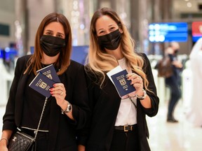 Israeli women pose for a picture with their passports upon arrival at the Dubai airport in the United Arab Emirates, on Nov. 26.