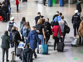 Police escort a group of passengers from the airport's Covid-19 testing center to their gate at Frankfurt International Airport in Frankfurt am Main, western Germany, on December 21, 2020.