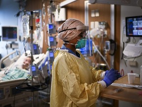 ICU health-care worker Jannikka Navaratnam cares for a patient inside a negative pressure room at the Humber River Hospital during the COVID-19 pandemic in Toronto on Wednesday, December 9, 2020.