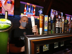 General manager Jason Reeb of The Cat 'n Fiddle Pub pours a beer as Premier Jason Kenney announces new restrictions in Calgary on Tuesday, Dec. 8, 2020.