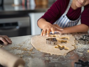 Child cutting dough for christmas cookies