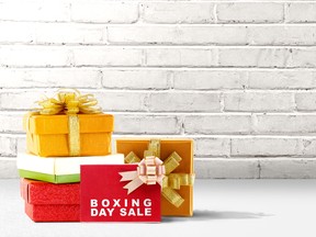 Pile of colorful gift box with ribbon and Boxing Day Sale text over brick wall background