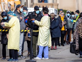 People wait in line to get a COVID-19 test at Mount Sinai Hospital as the city enters the first day of a renewed coronavirus lockdown due to a spike in cases in Toronto, November 23, 2020.