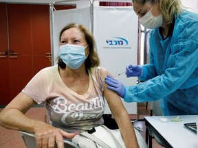 A woman receives a vaccination against the coronavirus disease (COVID-19) as Israel continues its national vaccination drive, during a third national COVID lockdown, at a Maccabi Healthcare Services branch in Ashdod, Israel December 29, 2020