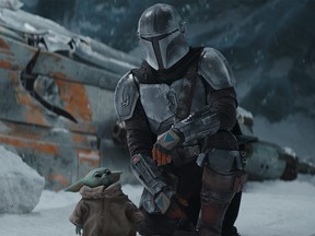Pedro Pascal, who plays the title role in Disney+'s The Mandalorian, is seen with baby Yoda in Episode #2.1 of Season 2.