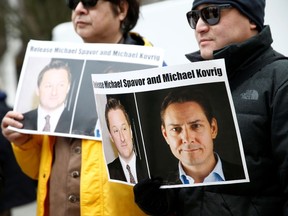 People hold signs calling for China to release Canadian detainees Michael Spavor and Michael Kovrig during an extradition hearing for Huawei Technologies Chief Financial Officer Meng Wanzhou at the B.C. Supreme Court in Vancouver, British Columbia, Canada, March 6, 2019.