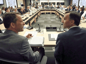 Deputy Minister Paul Rochon, left, speaks with then-federal Finance Minister Bill Morneau at a meeting with provincial and territorial finance ministers in Ottawa, Monday June 19, 2017.