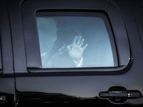 U.S. President Donald Trump waves from the presidential motorcade while arriving at Walter Reed National Military Medical Center in Bethesda, Maryland, U.S., on Friday, Oct. 2, 2020.