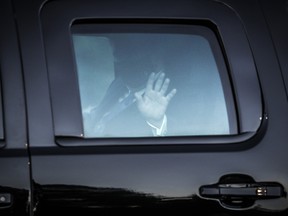 U.S. President Donald Trump waves from the presidential motorcade while arriving at Walter Reed National Military Medical Center in Bethesda, Maryland on Friday, Oct. 2, 2020, to be treated for Covid-19.