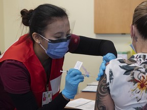 Nurse Venus Lucero administers the first Pfizer-BioNTech COVID-19 vaccine at The Ottawa Hospital to Jo-Anne Miner on Dec. 15, 2020.