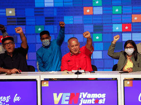 Members of the United Socialist Party of Venezuela raise their hands with a clenched fist in a sign of victory after midnight after the parliamentary elections where 277 parliamentarians were chosen with a participation of almost 70% abstention on December 7, 2020 in Caracas, Venezuela.