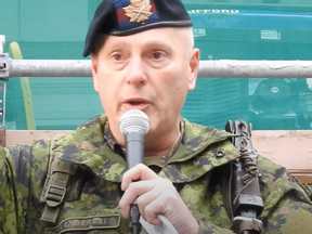 Ein Mitglied der kanadischen Streitkräfte, das von den Organisatoren einer Anti-Lockdown-Kundgebung vorgestellt wurde, als Leslie Kenderesi bei der Versammlung in Toronto spricht.
