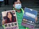 A pro-democracy activist holds a poster with the picture of Chinese citizen journalist Zhang Zhan outside the Chinese central government's liaison office, in Hong Kong, Monday, Dec. 28, 2020.