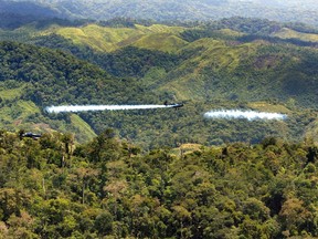 Colombian police fumigation planes spray herbicides on coca plants in the suburbs of Medellin 23 July 2003.