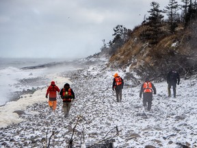 Members of a ground search and rescue team walk along the shore of the Bay of Fundy in Hillsburn, N.S. as they continue to look for five fishermen missing after the scallop dragger Chief William Saulis sank in the Bay of Fundy, on Wednesday, Dec. 16, 2020.
