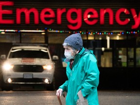 A lady wears a protective face mask to help prevent the spread of COVID-19 as they walk past the emergency department of the Vancouver General Hospital in Vancouver Wednesday, November 18, 2020.